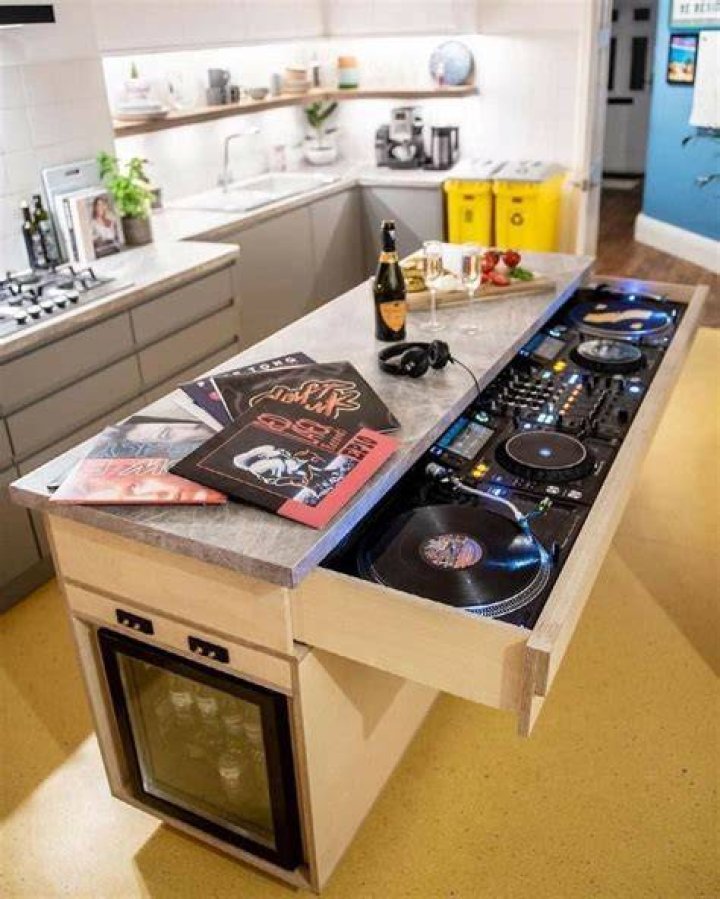DJ in the kitchen holding an ice cube on a stick as a popsicle