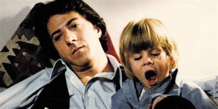 Dustin Hoffman looks tired while holding his young son in Kramer vs Kramer