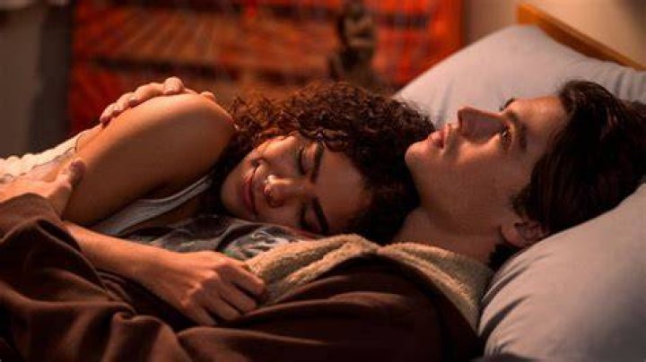 Ginny is lying on Marcus' chest. 