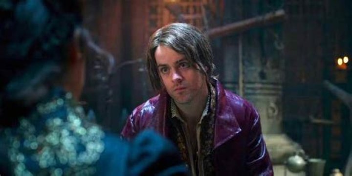 Jaskier looking serious next to Ciri desperate and crying in The Witcher