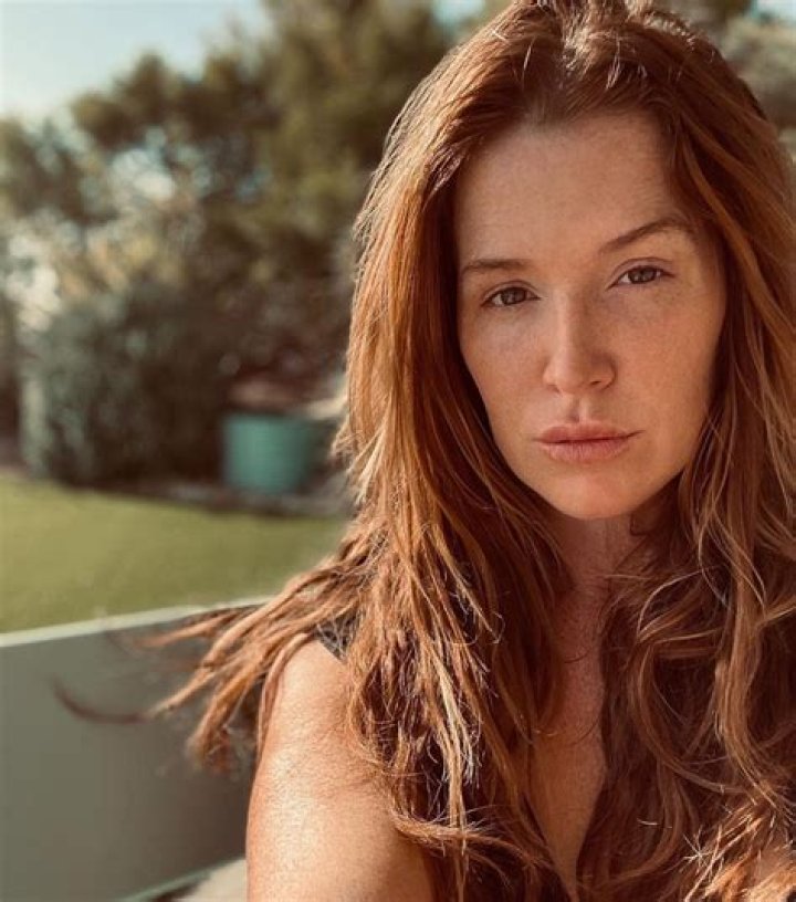 Poppy Montgomery with files and newspaper clippings around her in a promotional image for Secret City