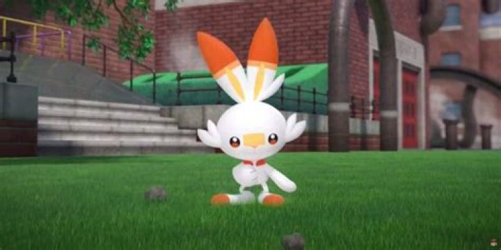 Scourbunny walks on a lawn in Pokemon: Sword & Shield.